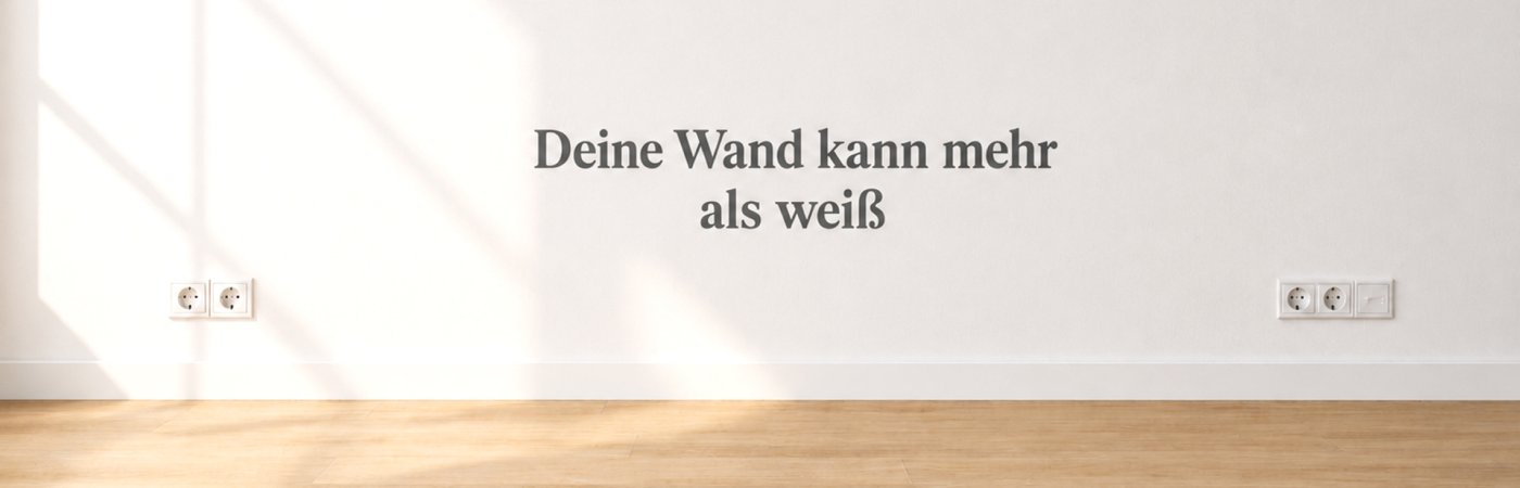 Gezeigt wird eine weiße Zimmerwand, auf der der Schriftzug deine Wand kann mehr als weiß steht