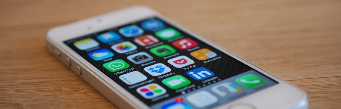 iPhone Ein IPhone liegt auf einem Holztisch