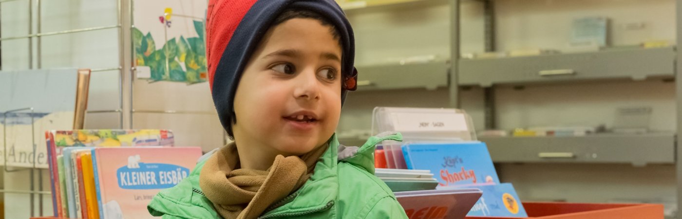 Junge in Kinderbibliothek Ein Junge sitzt in der Kinderbibliothek in Rheda und schaut zur Seite