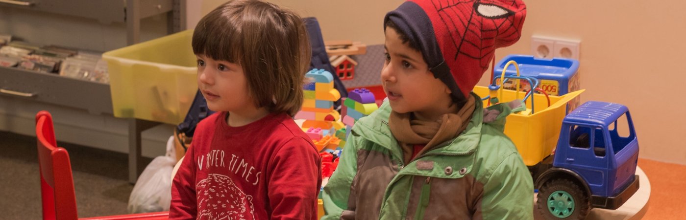Zwei Kinder sitzen vor den Bilderbuchtrögen in der Kinderbibliothek Rheda