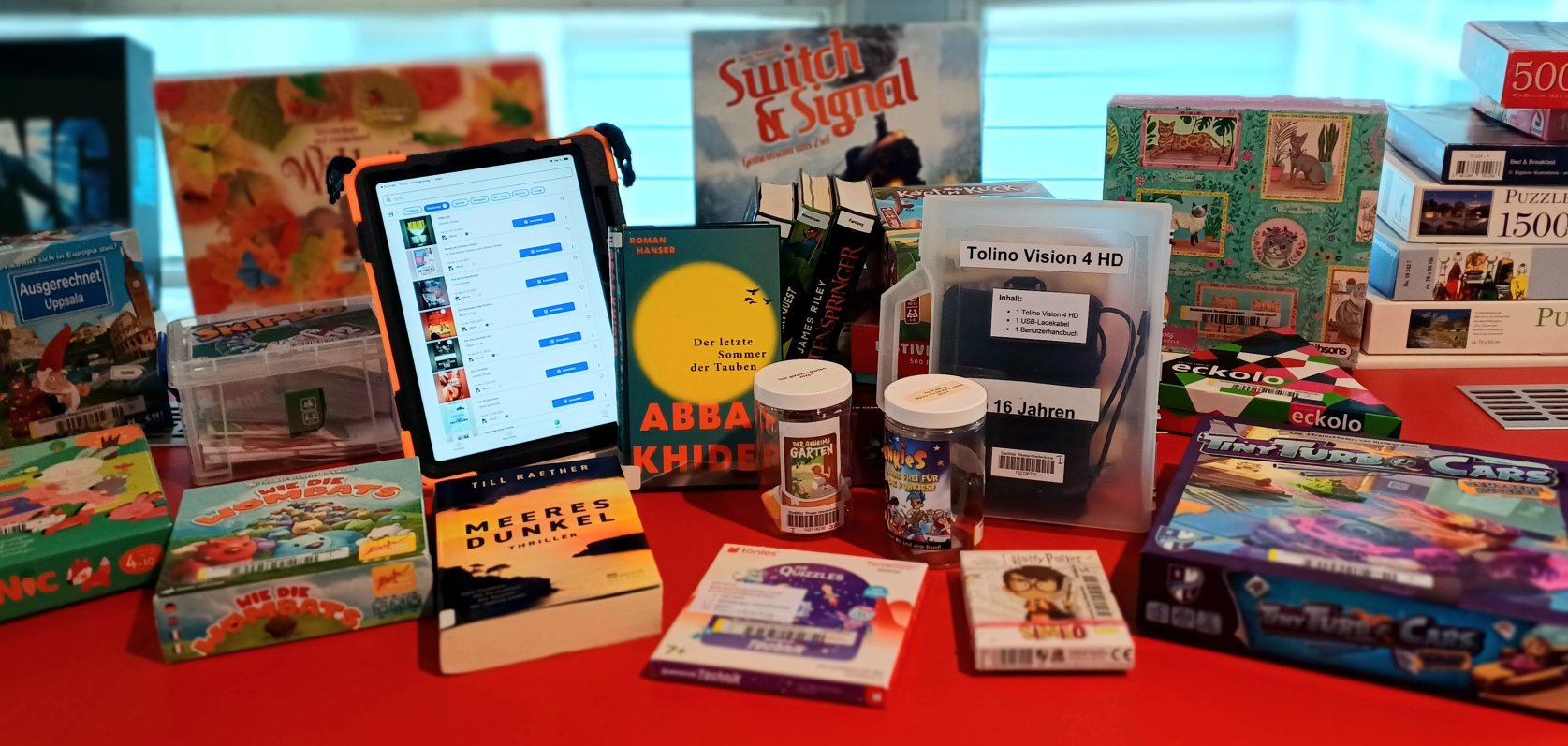 Gezeigt werden Bücher, ein Tablet, Tonies und Brettspiele