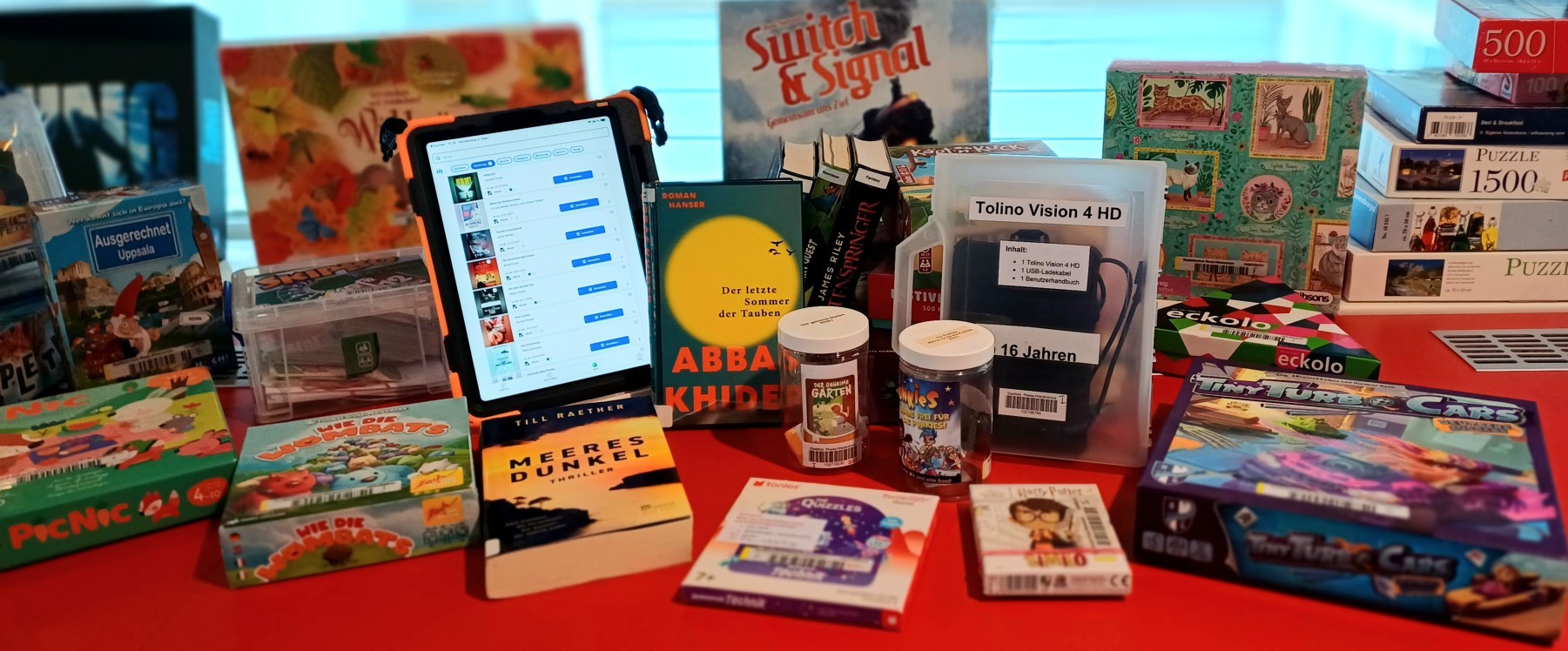 Gezeigt werden Bücher, ein Tablet, Tonies und Brettspiele