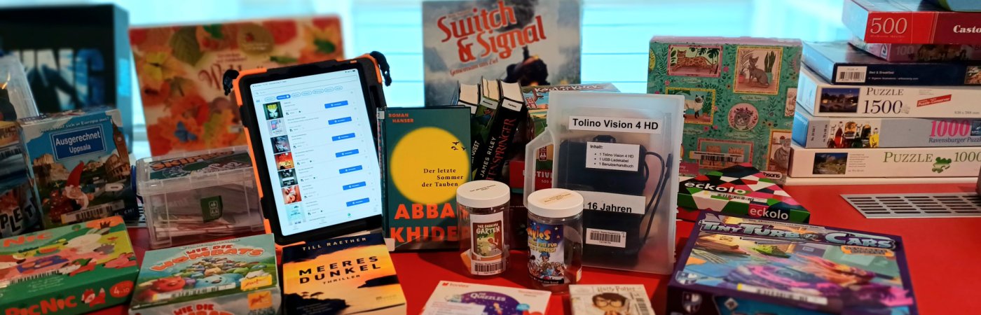 Gezeigt werden Spiele, Bücher, ein Tablet und Tonies