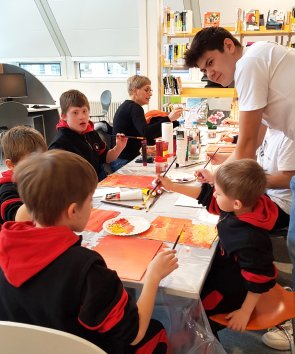 Eine Gruppe Kinder sitzt an einem Tisch und bastelt gemeinsam