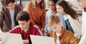 Gezeigt werden am Laptop arbeitende Jugendliche