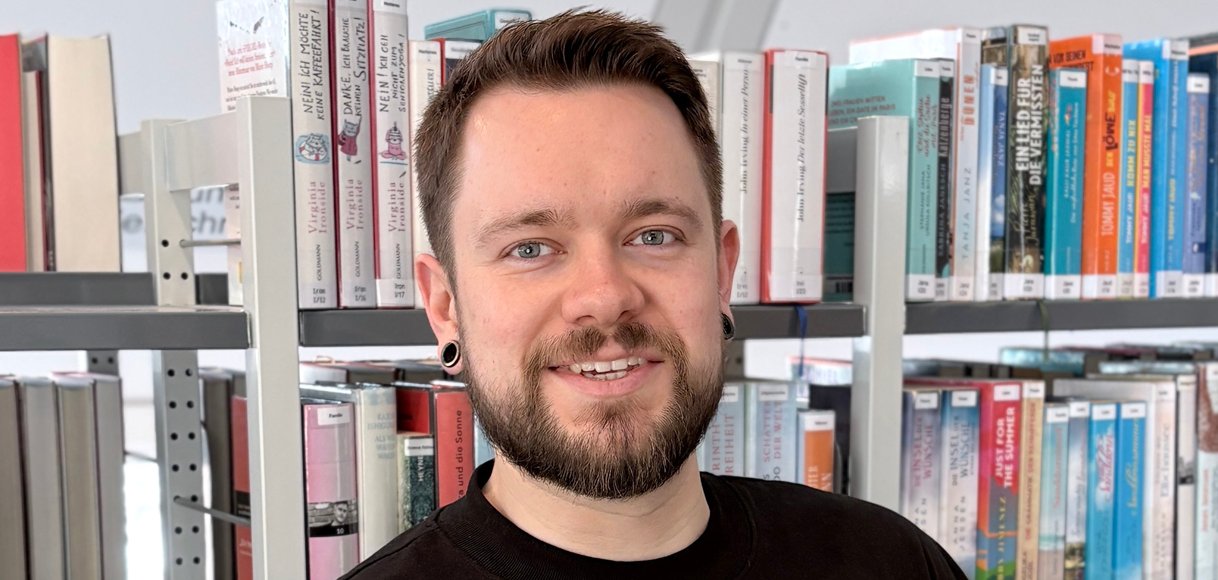 Gezeigt wird ein Mitarbeiter der Bibliothek