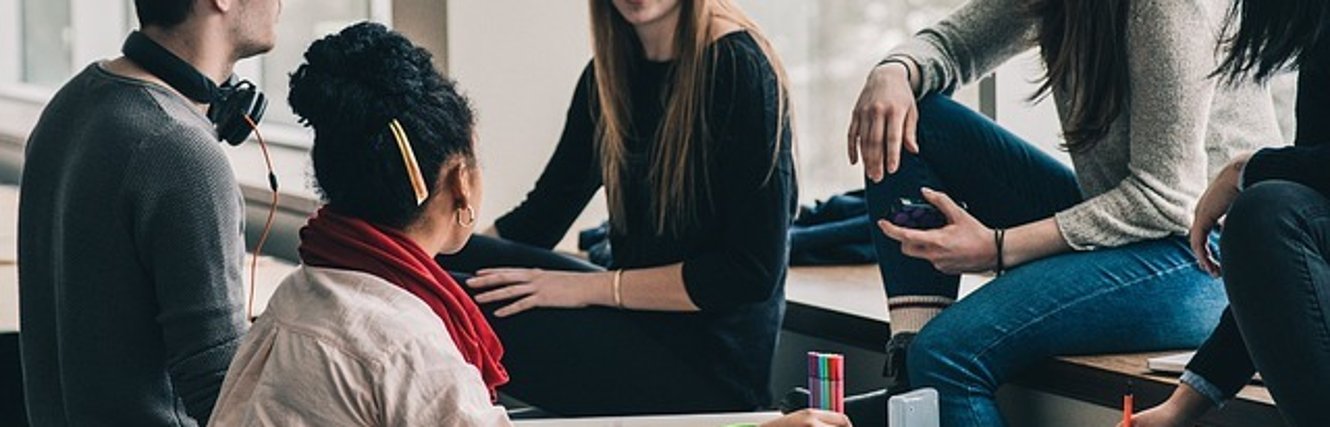 Gezeigt wird eine Gruppe lernender Jugendliche