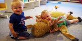 Zwei Jungen liegen auf einem Stofftier