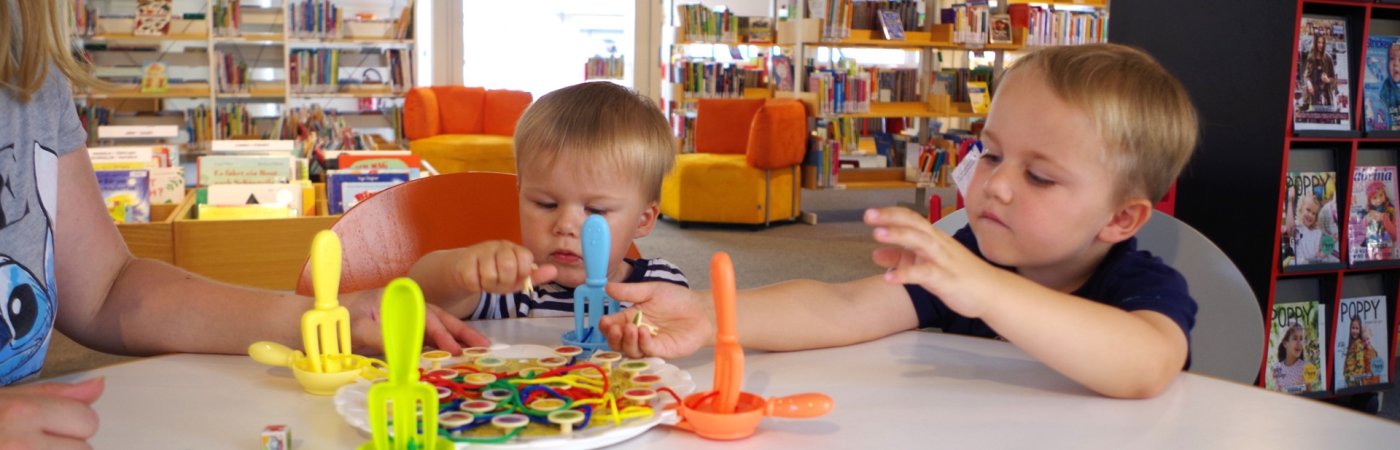 Zwei spielende Jungen Gezeigt werden zwei Kinder mit dem Stofftier Pauli
