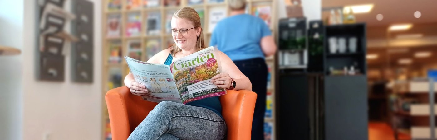 Gezeigt wird eine lesende Kundin, die im Lesecafé in Rheda sitzt