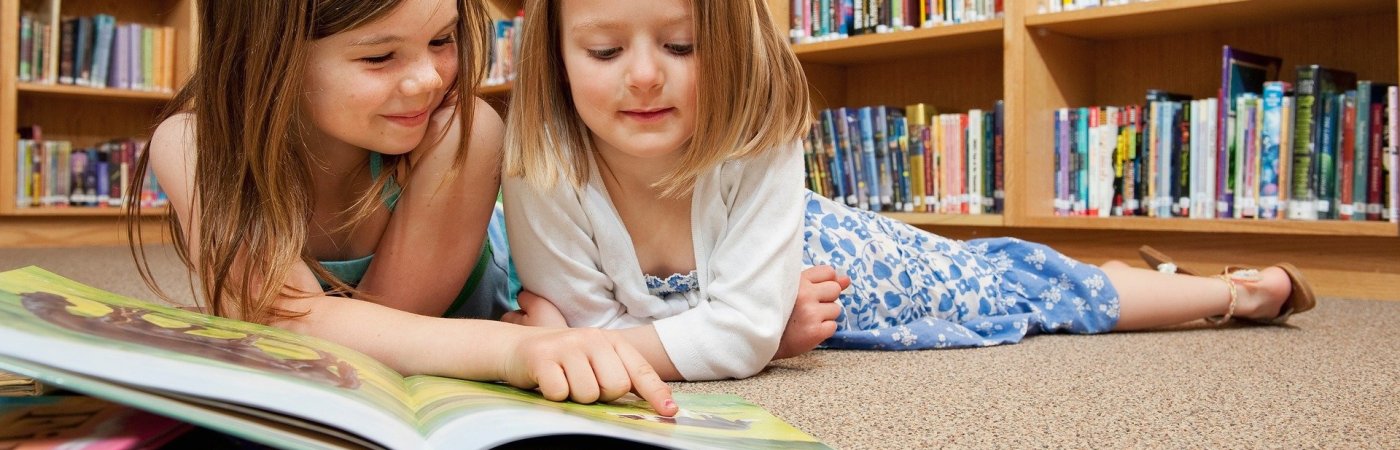 Lesende Mädchen Zwei Mädchen schauen in ein Buch