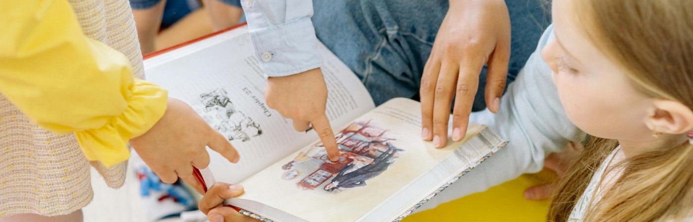 Eine Familie schaut in ein aufgeschlagenes Buch