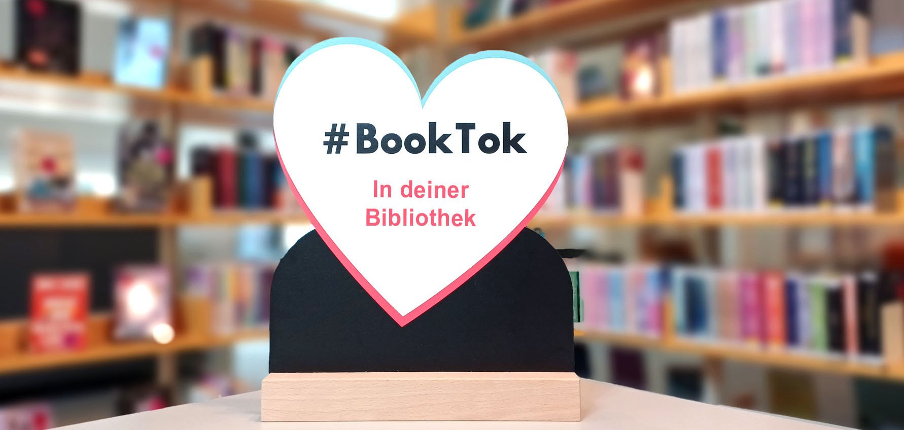 Gezeigt wird ein Herz als Aufsteller, auf dem der Schriftzug #Booktok in deiner Bibliothek steht