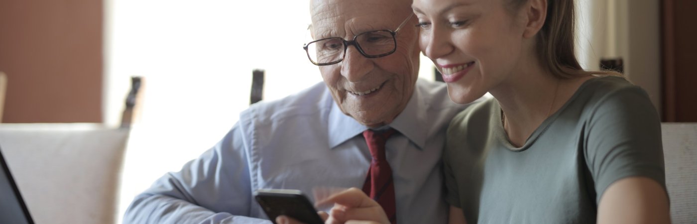 Gezeigt werden zwei Erwachsene vor einem Laptop