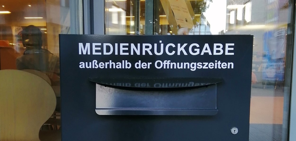 Gezeigt wird eine graue Metallbox mit der Aufschrift Medienrückgabe